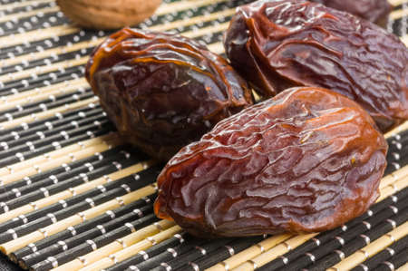Big luxury dried date fruit on the bamboo mat, kurma ramadan kareem concept.の写真素材