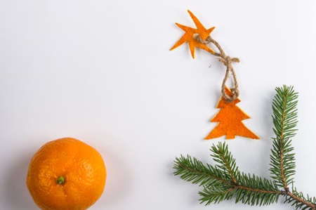 New Year Concept. Christmas decorations from tangerine peel, fir-tree branches and the fruits of mandarin orange on white backgroundの写真素材