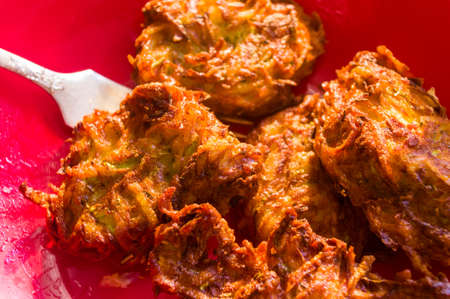 Fried vegetable fritters with zucchini, carrots, herbs, eggs, seasonings and cheese, close-up, selective focusの写真素材