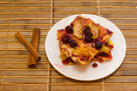 Homemade cookies with fruit in a white saucer on a bamboo mat, close upの写真素材