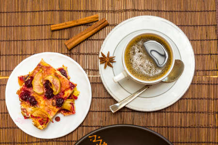 Still life - a cup of black coffee, homemade cookies with fruit, baked apples on a bamboo matの写真素材
