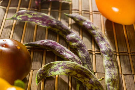 Still life - asparagus beans, purple Basil, yellow and chocolate tomatoes on bamboo Matの写真素材