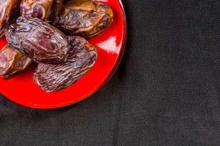 Big luxury dried date fruit in bowls on the dark surface, kurma ramadan kareem concept.の写真素材