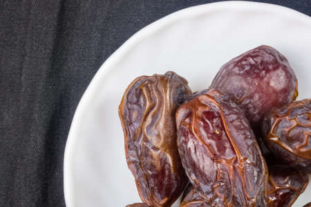 Big luxury dried date fruit in bowls on the dark surface, kurma ramadan kareem concept.の写真素材