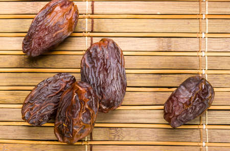 Big luxury dried date fruit on the bamboo mat, kurma ramadan kareem concept.の写真素材