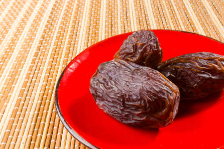 Big luxury dried date fruit in bowls on the bamboo mat, kurma ramadan kareem concept.の写真素材