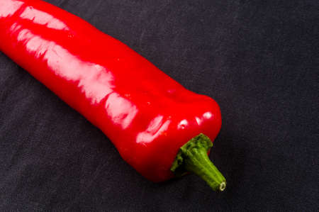 Fresh organic red chili peppers on a black background, close upの写真素材