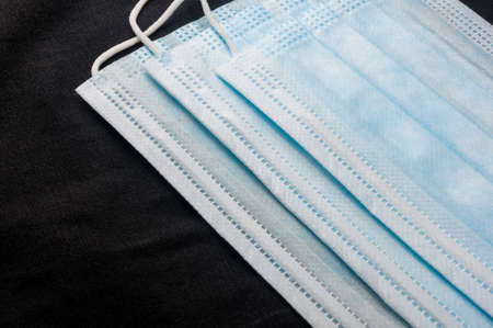 Background concept for news about the novel coronavirus COVID-19 pandemic, antiviral medical mask for protection against coronavirus. Surgical protective mask. Medical respiratory bandage face and thermometer, lettering on copy space.の写真素材