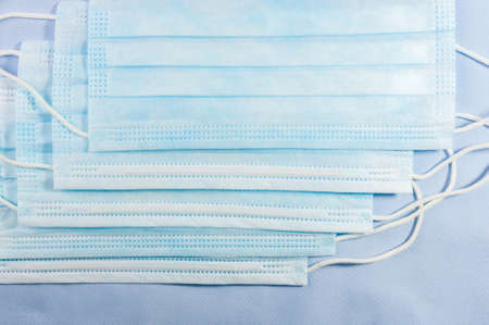 Background concept for news about the novel coronavirus COVID-19 pandemic, antiviral medical mask for protection against coronavirus. Surgical protective mask. Medical respiratory bandage face and thermometer, lettering on copy space.の写真素材