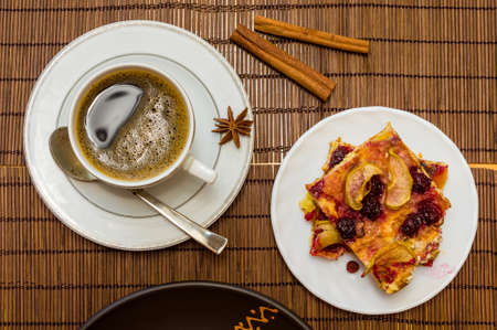 Still life - a cup of black coffee, homemade cookies with fruit, baked apples on a bamboo matの写真素材