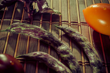 Still life - asparagus beans, purple Basil, yellow and chocolate tomatoes on bamboo Matの写真素材