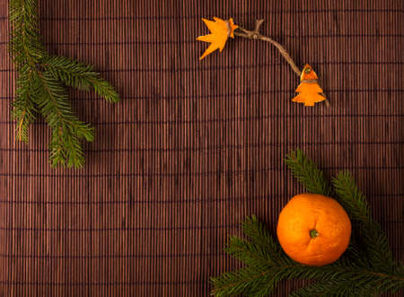 New Year Concept. Christmas decorations hand made from tangerine peel, fir-tree branches and the fruits of mandarin orange on bamboo mat backgroundの写真素材