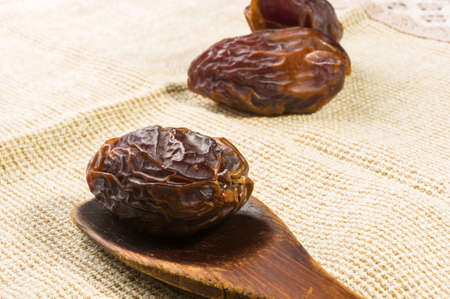Big luxury dried date fruit on a linen napkin, kurma ramadan kareem concept.の写真素材