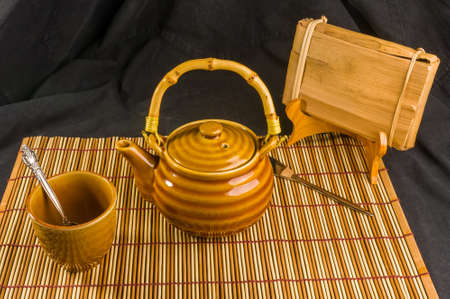 Chinese pressed PU-erh tea in bamboo leaf packaging and tea accessories on a bamboo Mat, close-upの写真素材