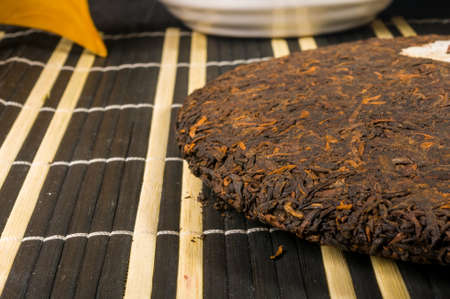 Chinese pressed PU-erh tea on bamboo mat, close-upの写真素材