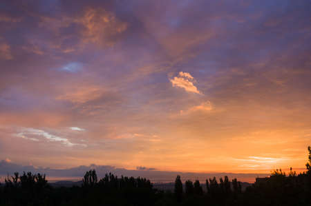 Landscape with dramatic light - beautiful golden sunset with saturated sky and clouds, peaceful nature serene background.の写真素材