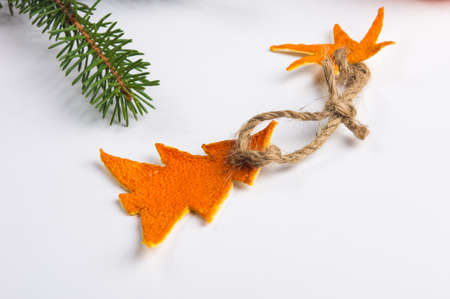 New Year Concept. Christmas decorations from tangerine peel and fir-tree branches on white backgroundの写真素材