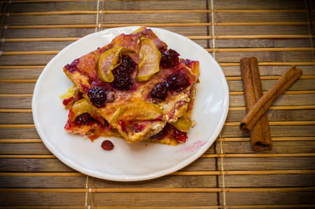 Homemade cookies with fruit in a white saucer on a bamboo mat, close upの写真素材