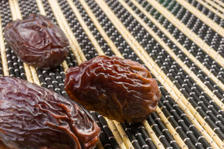 Big luxury dried date fruit on the bamboo mat, kurma ramadan kareem concept.の写真素材