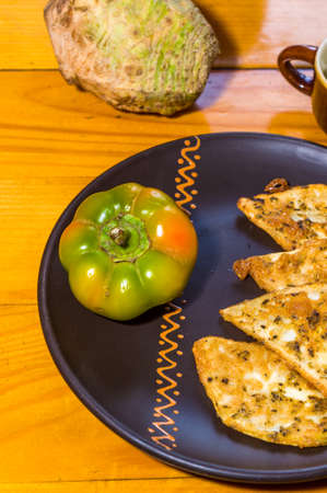 Vegetarian food - celery tuber slices fried in batter in a ceramic plate on a wooden tableの写真素材