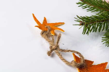 New Year Concept. Christmas decorations from tangerine peel and fir-tree branches on white backgroundの写真素材
