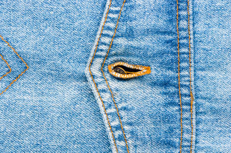 clothing items blue washed faded jeans cotton fabric texture with seams, clasps, buttons and rivets, macroの写真素材