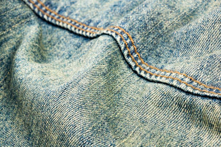 clothing items blue washed faded jeans cotton fabric texture with seams, clasps, buttons and rivets, macroの写真素材