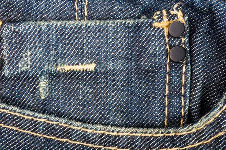 clothing items blue washed faded jeans cotton fabric texture with seams, clasps, buttons and rivets, macroの写真素材
