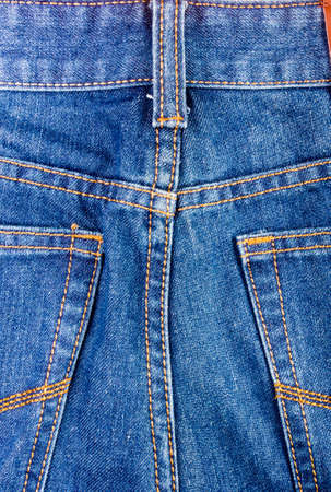 clothing items blue washed faded jeans cotton fabric texture with seams, clasps, buttons and rivets, macroの写真素材