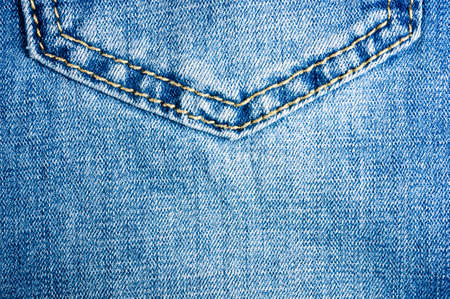 clothing items blue washed faded jeans cotton fabric texture with seams, clasps, buttons and rivets, macroの写真素材
