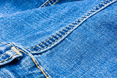 clothing items blue washed faded jeans cotton fabric texture with seams, clasps, buttons and rivets, macroの写真素材