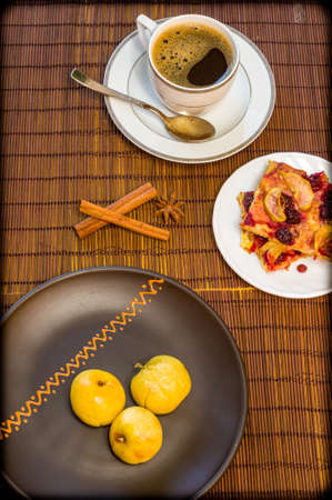 Still life - a cup of black coffee, homemade cookies with fruit, baked apples on a bamboo matの写真素材
