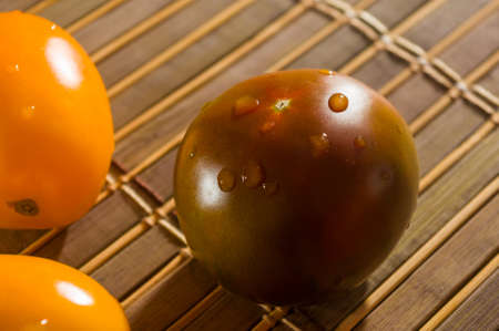 Still life - yellow and chocolate tomatoes on bamboo Matの写真素材