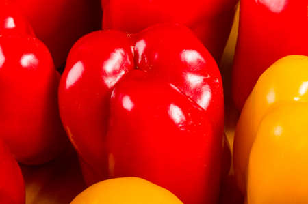 a colorful mix of the freshest red and yellow paprika, bell pepper on wooden background, close upの写真素材