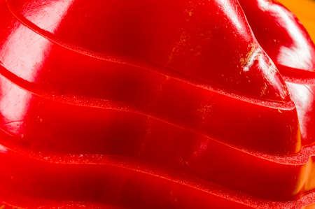 stacked pile of sliced fresh red paprika, bell pepper on bamboo cutting Board, close upの写真素材