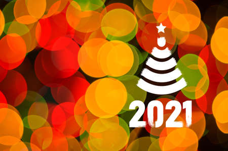 Christmas background-garlands with colorful lights on a decorated Christmas tree, bokeh, Happy New Year 2021 colored symbol and text in trendy flatten style design.の写真素材