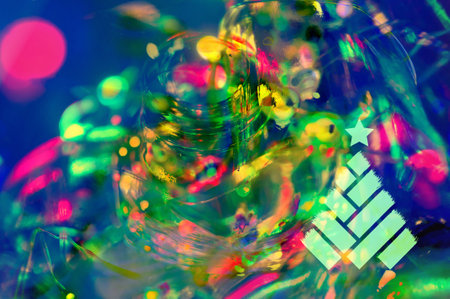 Glowing Christmas multicolored LED garland in a glass bottle, black background, macro, close-up