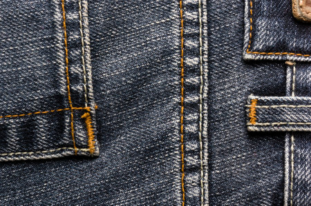 clothing items blue washed faded jeans cotton fabric texture with seams, clasps, buttons and rivets,...