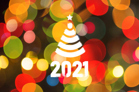 Christmas background-garlands with colorful lights on a decorated Christmas tree, bokeh, Happy New Year 2021 colored symbol and text in trendy flatten style design for seasonal holidays flyers, greetings and invitations cards and christmas themed congratulations and bannersの写真素材