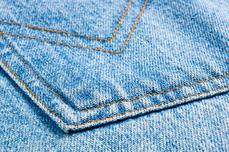 clothing items blue washed faded jeans cotton fabric texture with seams, clasps, buttons and rivets, macroの写真素材