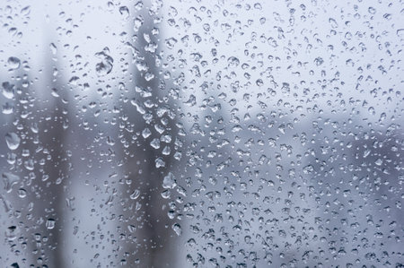 Melting snow on the glass, drops of water condensation on the window, and transparent glass of the...