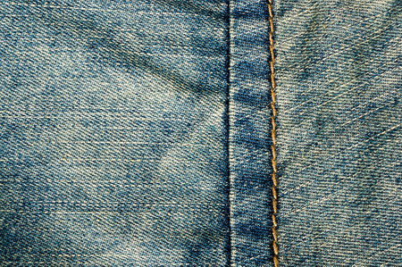 clothing items blue washed faded jeans cotton fabric texture with seams, clasps, buttons and rivets, macroの写真素材