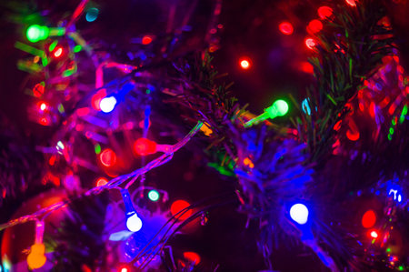 Christmas background-garlands with colorful lights on a decorated Christmas tree, bokeh, close-upの写真素材