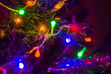 Christmas background-garlands with colorful lights on a decorated Christmas tree, bokeh, close-upの写真素材