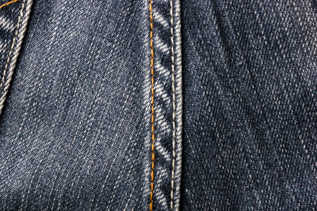 clothing items blue washed faded jeans cotton fabric texture with seams, clasps, buttons and rivets, macroの写真素材