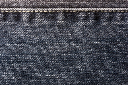 clothing items blue washed faded jeans cotton fabric texture with seams, clasps, buttons and rivets, macroの写真素材