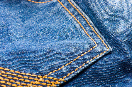 clothing items blue washed faded jeans cotton fabric texture with seams, clasps, buttons and rivets, macroの写真素材