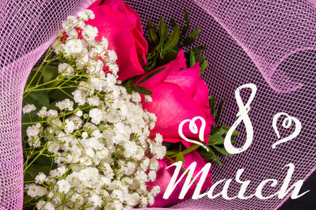 Holiday card - a bouquet of fresh red roses in a festive package, holiday greetings, handwritten inscription with a brush 8 march, greeting lettering.の写真素材