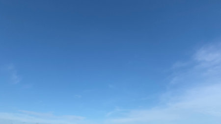 Blue sky with misty clouds, sunlight shining on the horizonの写真素材