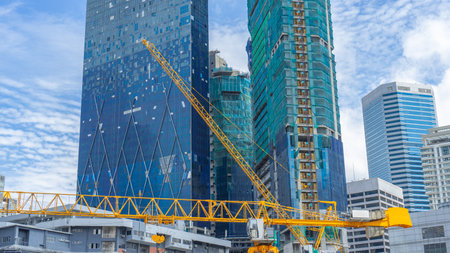 Location photograph, vertical image, blue building, skeleton of a building several dozen stories...